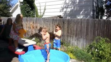 Topless boys have water fight